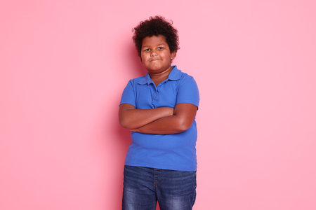 Portrait of cute little boy on pink background