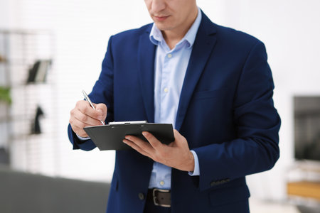 Real estate appraisal. Inspector with folder conducting property valuation at home, closeupの写真素材