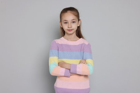 Portrait of cute girl on gray background
