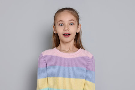 Portrait of cute girl on gray backgroundの写真素材