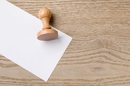 One wooden stamp and blank sheet of paper on table, top view. Space for textの写真素材