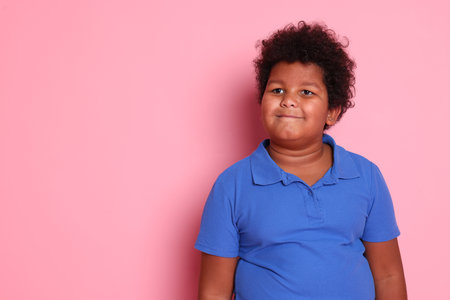Portrait of cute little boy on pink background, space for textの写真素材