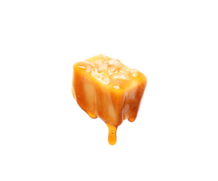 Tasty candy with salt and caramel sauce isolated on whiteの写真素材