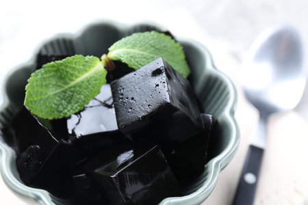 Tasty herbal jelly with mint leaves on light table, closeupの写真素材