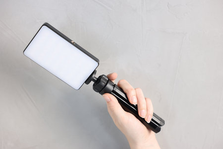 Woman with LED lamp on light background, closeup.の写真素材