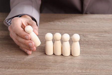 Man with human figures at wooden table, closeupの写真素材