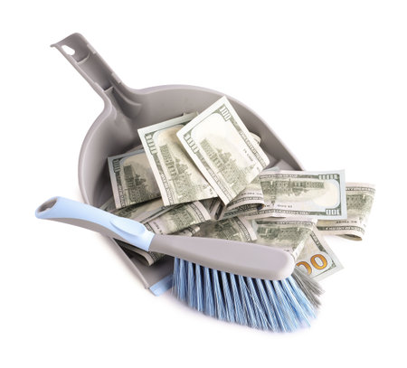 Dustpan with broom and dollar banknotes isolated on whiteの写真素材