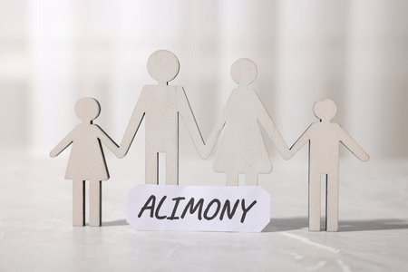 Paper note with word Alimony and figures of family on gray marble table, closeupの写真素材
