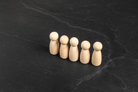 Many human figures on black table, closeup