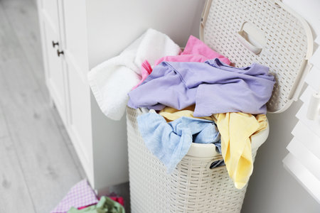 Laundry basket full of clothes indoors, closeupの写真素材