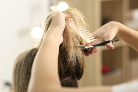 Hairdresser cutting woman's hair in salon, closeupの写真素材