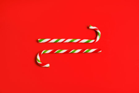 Candy canes on red background, flat lay. Christmas treatの写真素材