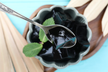 Eating tasty herbal jelly at light blue table, top viewの写真素材