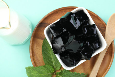 Tasty herbal jelly in bowl, mint and milk on light blue background, flat layの写真素材