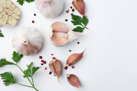 Garlic, peppercorns and parsley on white table, flat lay. Space for textの写真素材