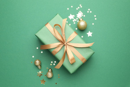 Beautiful Christmas composition with gift and decor on green background, flat layの写真素材