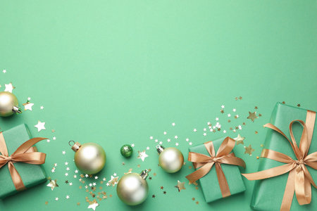 Beautiful Christmas composition with gifts and decor on green background, flat lay. Space for textの写真素材