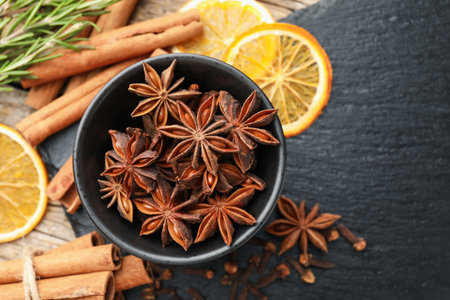 Different spices, fresh rosemary and dry orange slices for mulled wine on table, flat lay. Space for textの写真素材