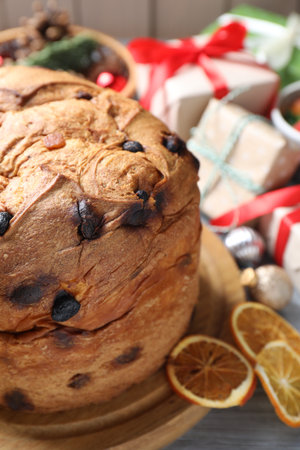 Tasty Christmas panettone cake, dry orange slices and gift boxes on table, closeupの写真素材