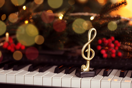 Golden treble clef and Christmas decor on piano, closeup. Space for textの写真素材