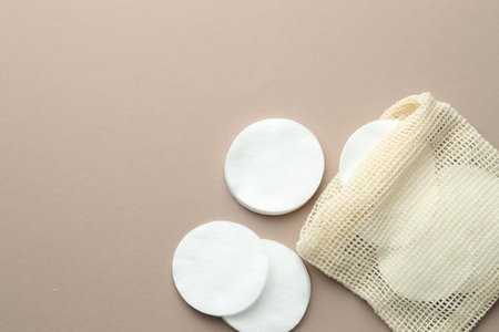 Clean cotton pads and bag on beige background, flat lay. Space for textの写真素材