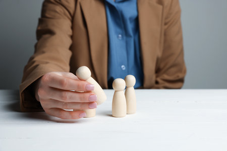 Woman with human figures at white wooden table, closeupの写真素材