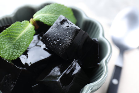 Tasty herbal jelly with mint leaves on light table, closeupの写真素材