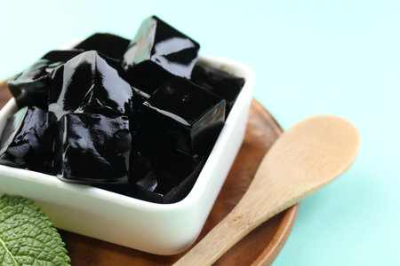 Tasty herbal jelly in bowl and mint on light blue background, closeupの写真素材
