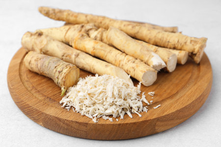 Whole and gratified horseradish roots on light gray table, closeupの写真素材