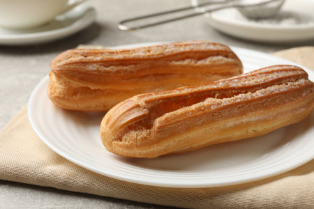 Delicious eclairs on light gray table, closeup