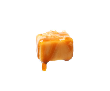 Tasty candy with salt and caramel sauce isolated on whiteの写真素材