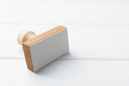 One wooden stamp on white table, closeup. Space for textの写真素材