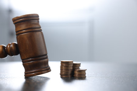 Alimony. Gavel and coins on dark table, closeup. Space for textの写真素材