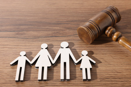 Alimony. Figures of family and judge's gavel on wooden table, closeupの写真素材