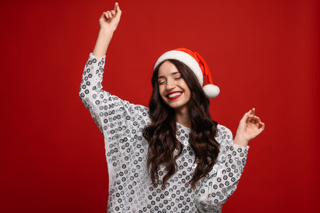 Beautiful woman with Santa hat on red background. Christmas seasonの写真素材