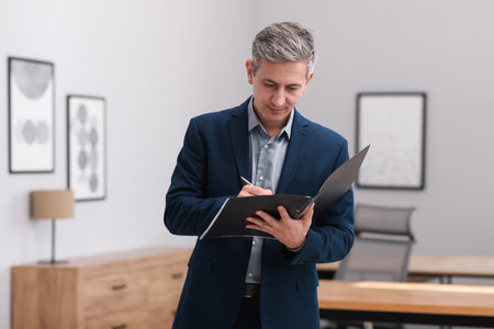 Real estate appraisal. Inspector with folder conducting property valuation at homeの写真素材