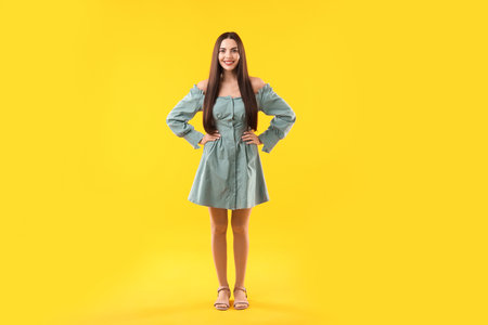 Beautiful woman in stylish dress on orange backgroundの写真素材