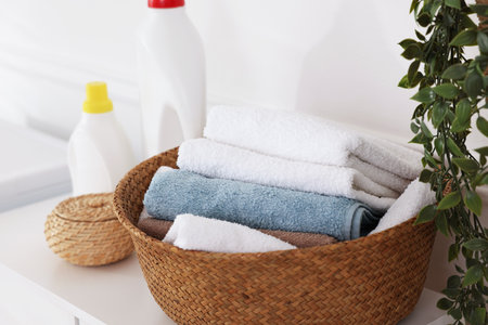 Laundry basket with towels and detergents on white cabinet indoors, closeupの写真素材