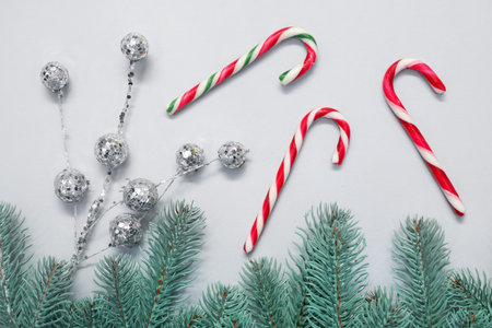 Flat lay composition with candy canes on light background. Christmas treat
