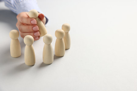 Woman with human figures at white table, closeup. Space for textの写真素材