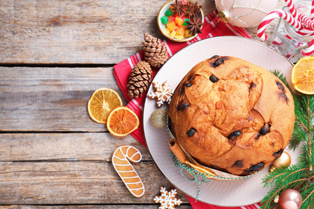 Tasty Christmas panettone cake and decor on wooden table, flat lay. Space for textの写真素材