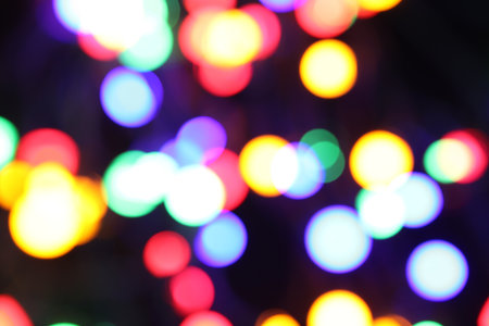 Blurred view of bright Christmas lights on dark background, bokeh effectの写真素材