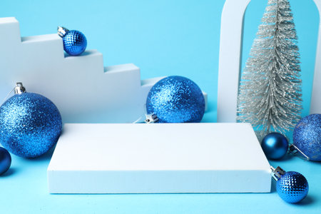 Empty podium and Christmas decor on light blue background, closeup. Space for textの写真素材