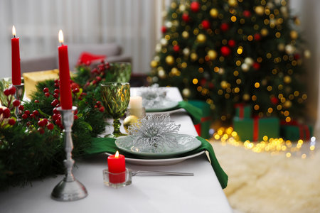 Festive table setting with Christmas decor and burning candles indoors, closeupの写真素材