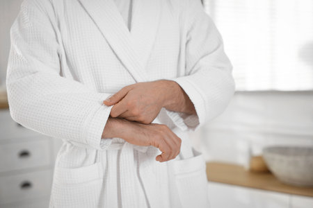 Man wearing comfortable white bathrobe indoors, closeupの写真素材