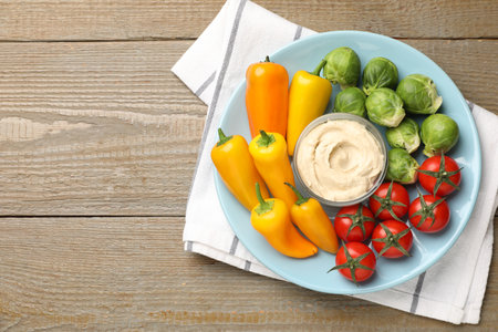 Different fresh vegetables and sauce on wooden table, top view. Space for textの写真素材