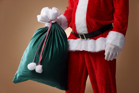 Santa Claus holding sack on beige background, closeup. Merry Christmas and Happy New Yearの写真素材