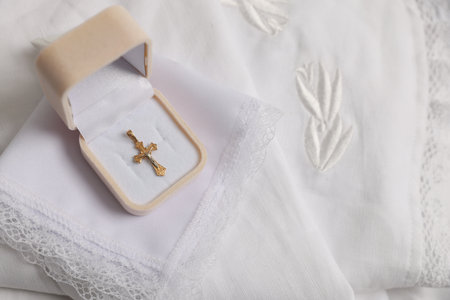 Sacrament of baptism. Box with gold cross and christening towel on bed, top viewの写真素材