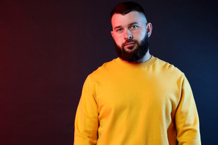 Portrait of handsome man on dark background with color lights. Space for textの写真素材