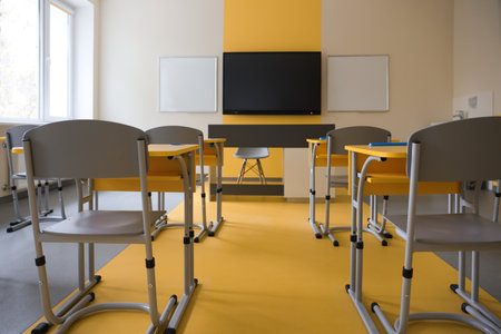 Stylish classroom with desks, chairs and TV at schoolの写真素材